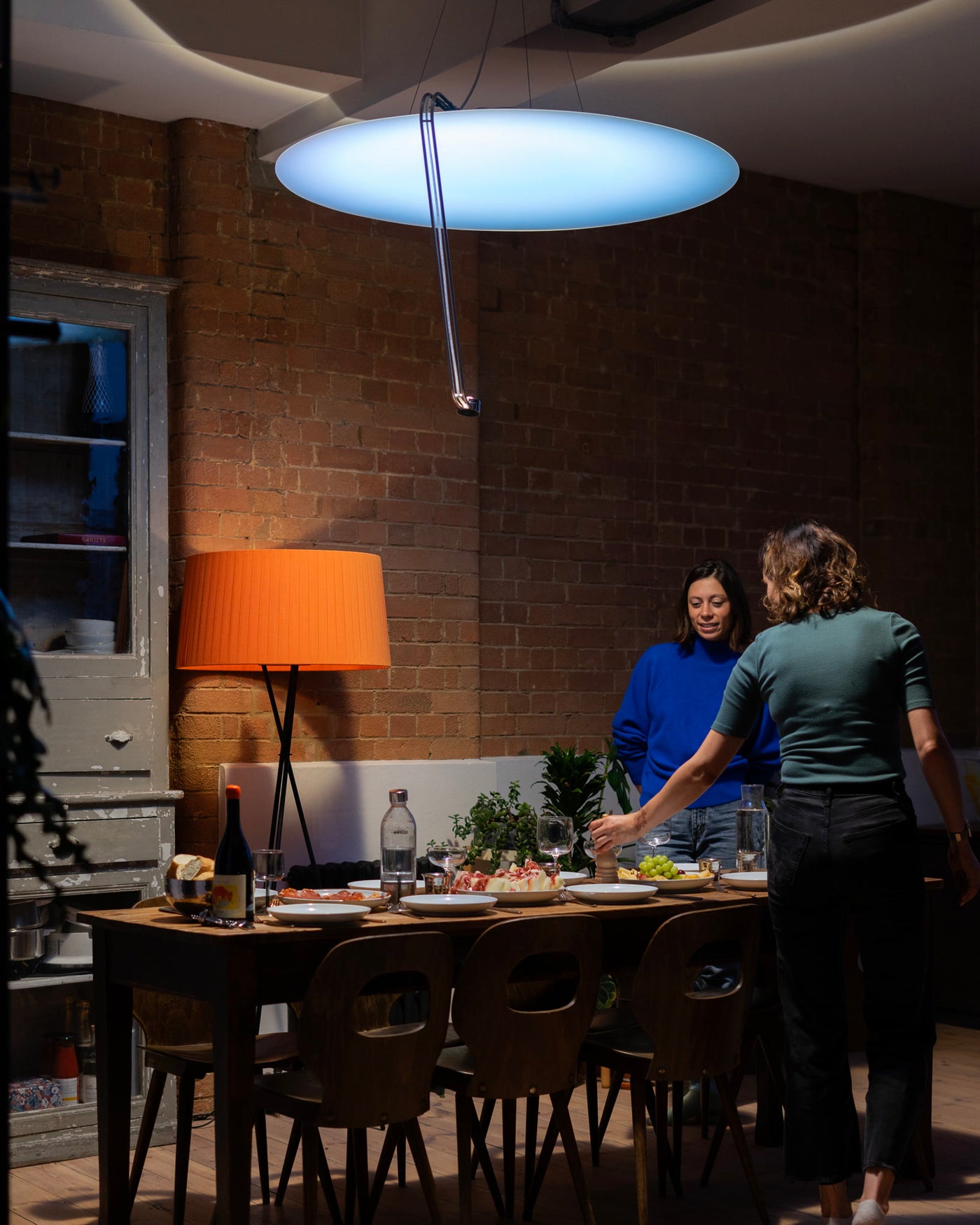 Sunday Light above a dinner table in a brick loft during a warm evening gathering