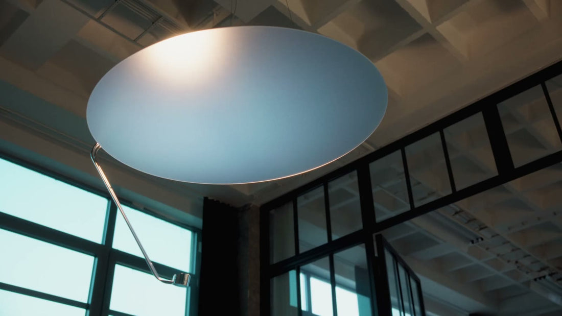 Sunday Light hanging beneath a coffered concrete ceiling beside steel-framed windows