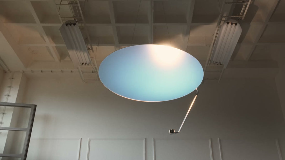 Sunday Light seen from below in a tall white room, the sheet glowing blue with a warm centre