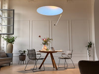 Indoor sunlight artificial skylight ceiling light in a Modern dining room with wooden table, chairs.
