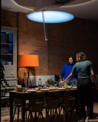 Sunday Light above a dinner table in a brick loft during a warm evening gathering